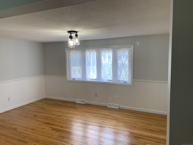 31 Gary Dr, Enfield, CT 06082 - unfurnished room with hardwood / wood-style floors, a wainscoted wall, and a textured ceiling