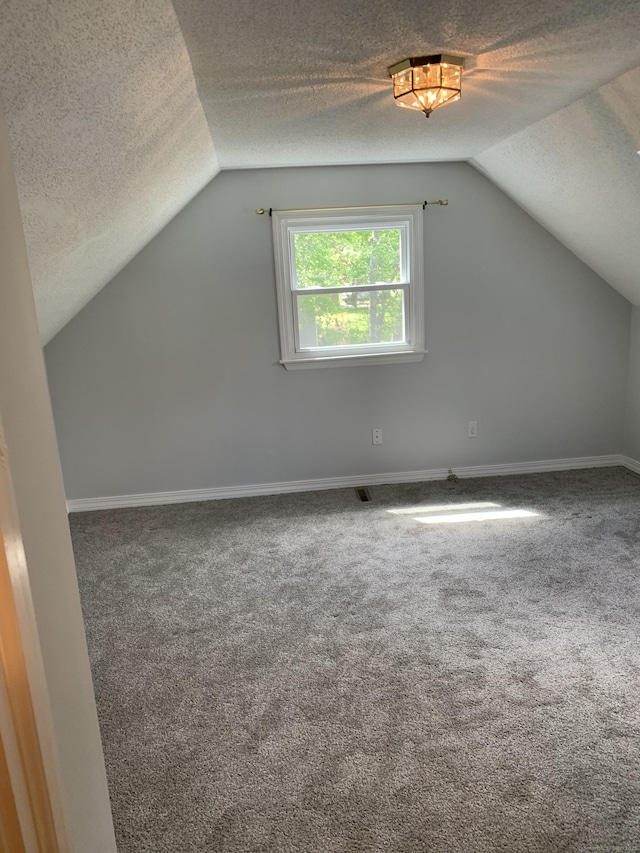 31 Gary Dr, Enfield, CT 06082 - bonus room featuring a textured ceiling, carpet flooring, vaulted ceiling, and baseboards