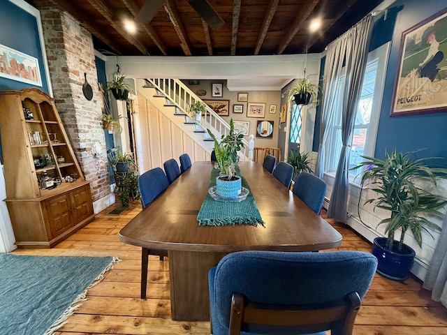 dining space featuring wooden ceiling, beamed ceiling, brick wall, and hardwood / wood-style flooring