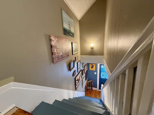 stairs featuring crown molding and hardwood / wood-style floors