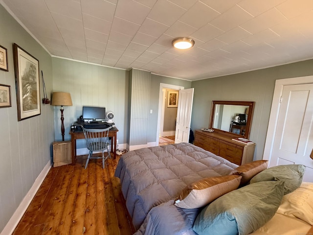 bedroom with dark hardwood / wood-style floors and ornamental molding