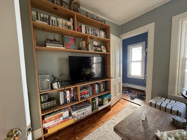 sitting room featuring baseboard heating, radiator, a textured ceiling, and hardwood / wood-style flooring