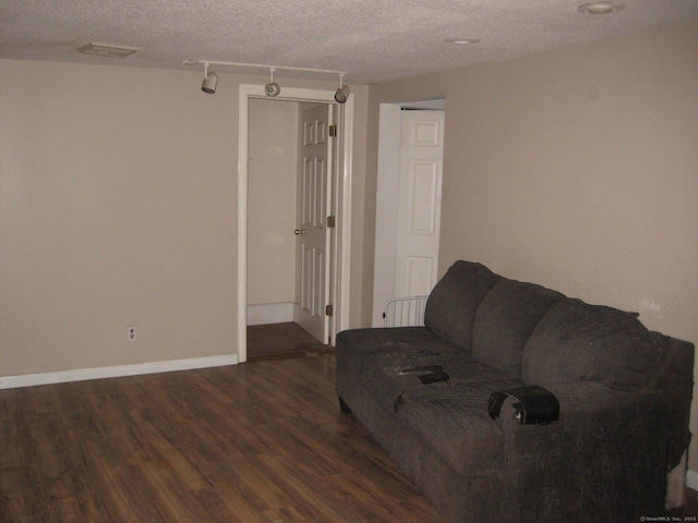 living room with a textured ceiling and dark hardwood / wood-style flooring