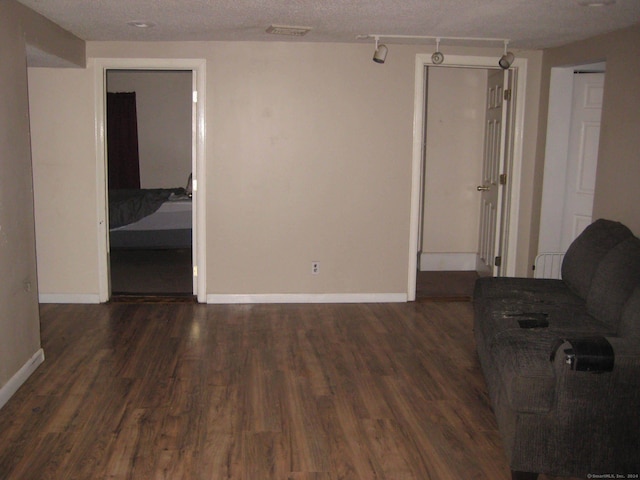 unfurnished living room with a textured ceiling and dark hardwood / wood-style floors