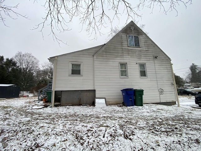 view of snow covered back of property