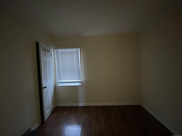 empty room with dark wood-type flooring