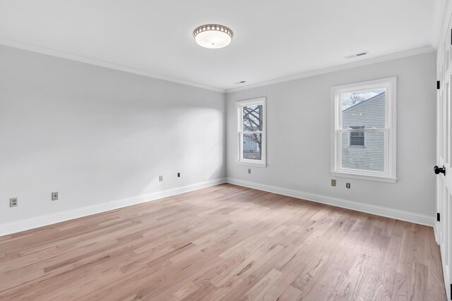 spare room with crown molding and light wood-type flooring