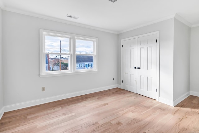 unfurnished bedroom featuring a closet, light hardwood / wood-style floors, and ornamental molding