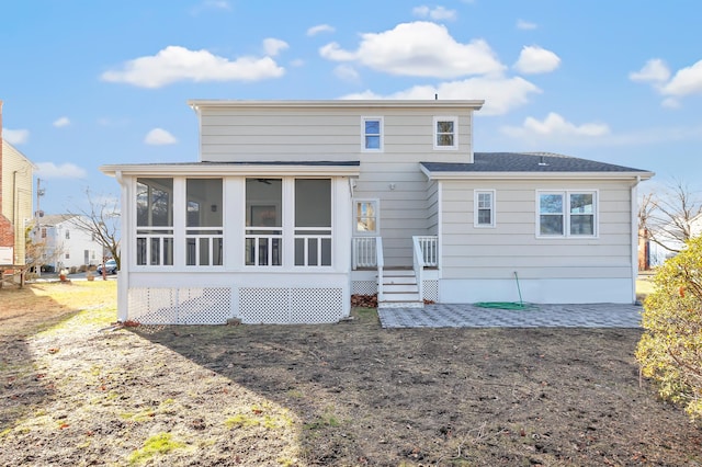 rear view of property featuring a sunroom