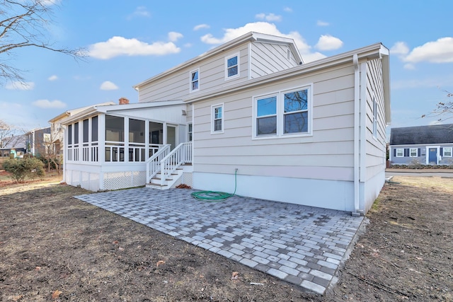 back of property with a patio area and a sunroom