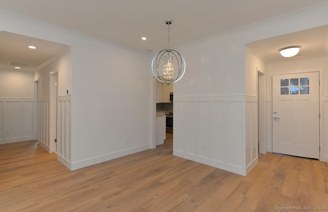 interior space featuring light hardwood / wood-style floors, crown molding, and a chandelier