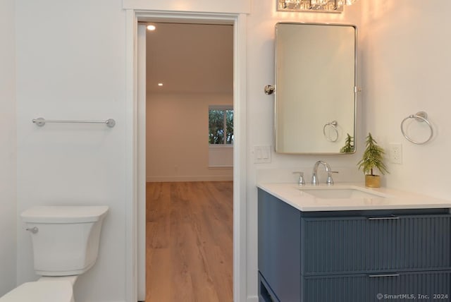 bathroom featuring wood-type flooring, vanity, and toilet