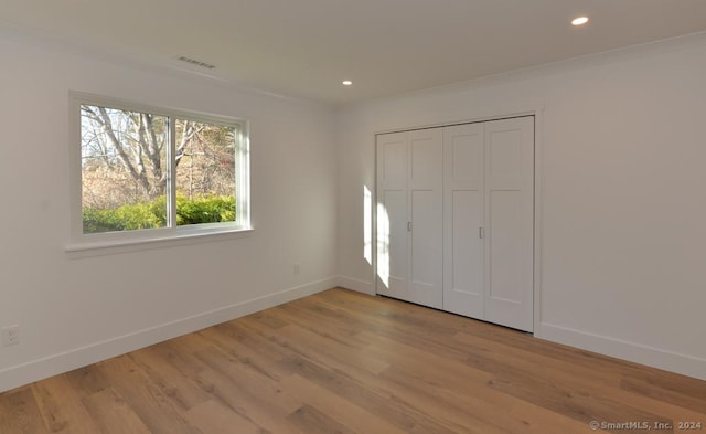 unfurnished bedroom featuring a closet and light wood-type flooring