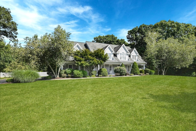 cape cod home featuring a front lawn