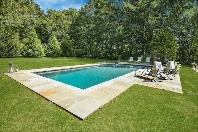 pool with a patio and a yard