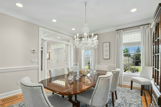 dining room featuring a wealth of natural light, ornamental molding, visible vents, and light wood-style floors