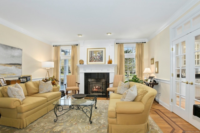 living room with ornamental molding, a healthy amount of sunlight, a fireplace with flush hearth, and wood finished floors