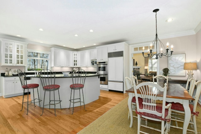 kitchen featuring stainless steel double oven, white cabinetry, and dark countertops