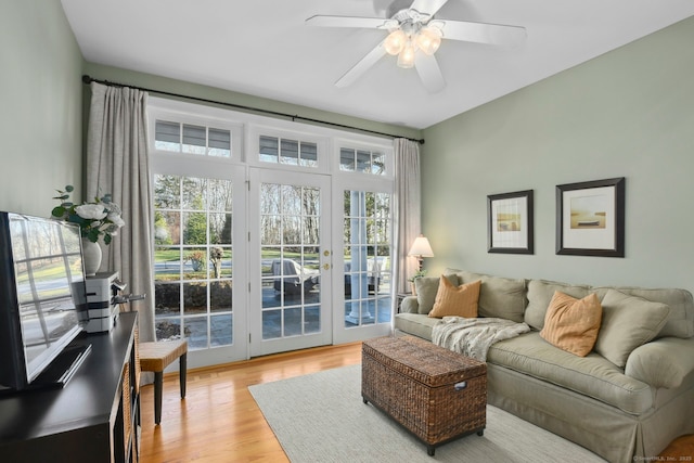 living area with light wood finished floors and a ceiling fan