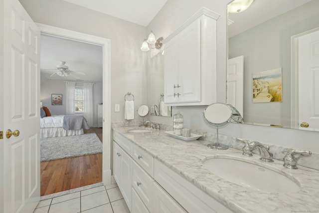 bathroom with ensuite bathroom, double vanity, a sink, and tile patterned floors