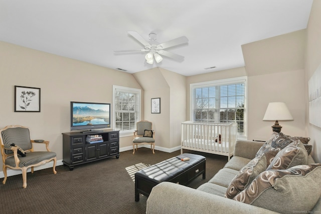 living room with a ceiling fan, dark colored carpet, visible vents, and baseboards