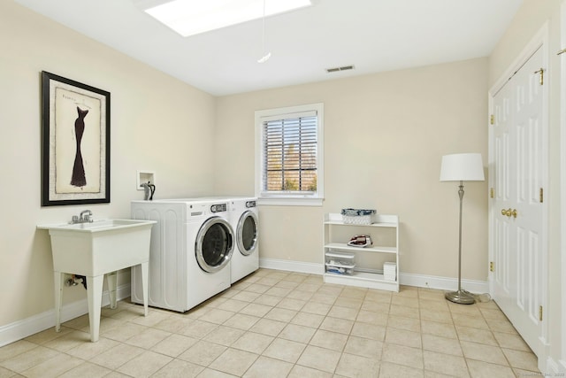 clothes washing area with laundry area, light tile patterned floors, baseboards, visible vents, and washer and dryer