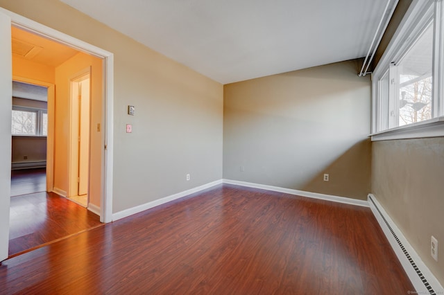 unfurnished room with dark hardwood / wood-style flooring and a baseboard radiator