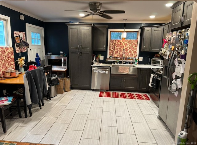 kitchen featuring stainless steel appliances, hanging light fixtures, crown molding, and ceiling fan