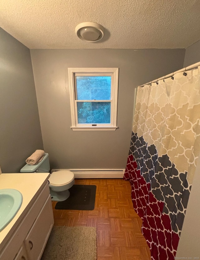 bathroom with parquet floors, vanity, a textured ceiling, a baseboard radiator, and toilet