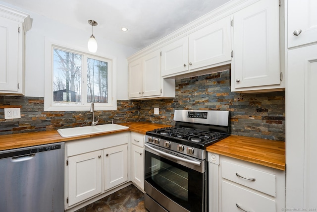 kitchen featuring hanging light fixtures, white cabinetry, sink, and appliances with stainless steel finishes