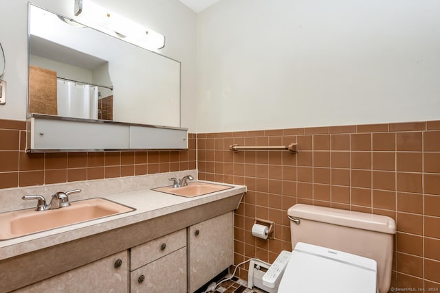 bathroom with vanity, toilet, and tile walls