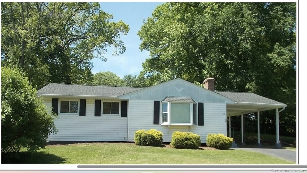 view of front of home with a front yard and a carport