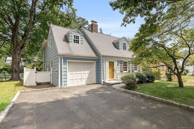 cape cod-style house featuring a porch, a garage, and a front yard