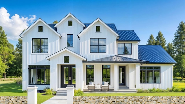 back of property with a yard and french doors