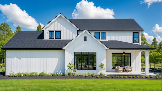 back of house featuring a lawn, ceiling fan, and a patio