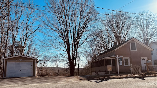 view of home's exterior with a garage, an outdoor structure, and a sunroom