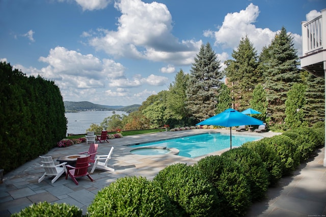 view of pool with a water and mountain view, a fire pit, a pool with connected hot tub, and a patio area