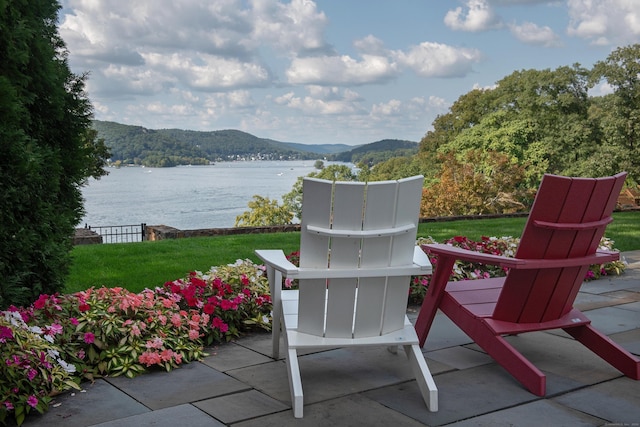 view of patio featuring a forest view and a water and mountain view