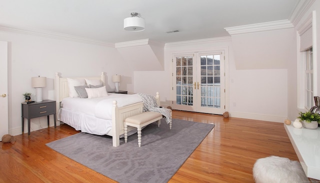 bedroom featuring wood finished floors, visible vents, ornamental molding, french doors, and access to outside