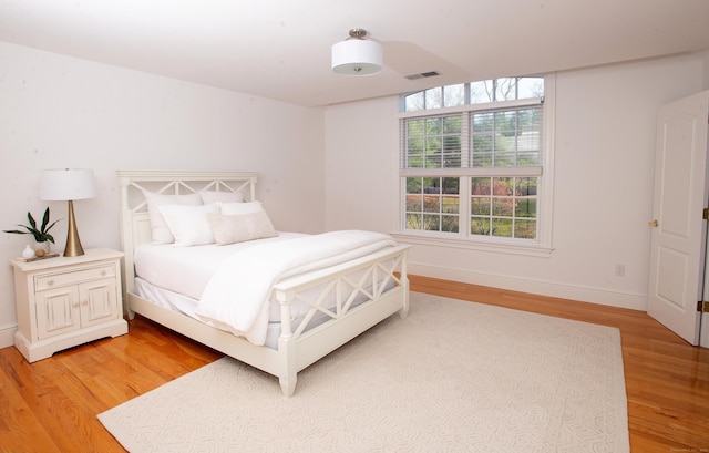 bedroom featuring visible vents, baseboards, and light wood-style flooring