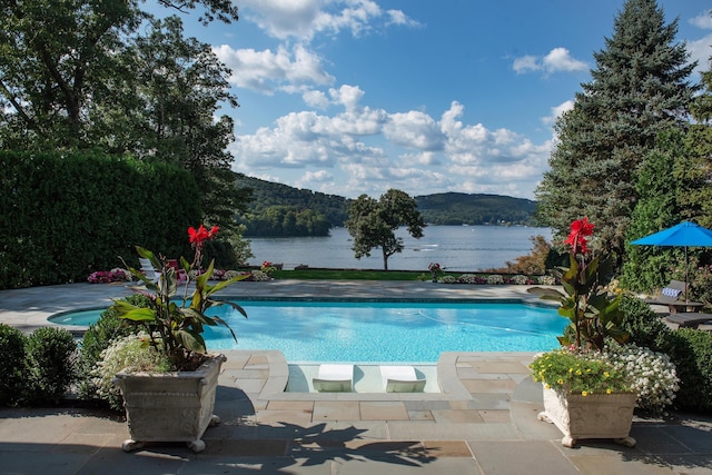 pool featuring a water view and a patio