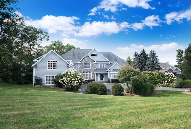 view of front of property with stone siding and a front yard