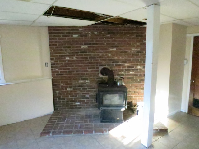 interior details with a paneled ceiling and a wood stove