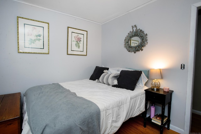 bedroom with dark hardwood / wood-style floors and ornamental molding