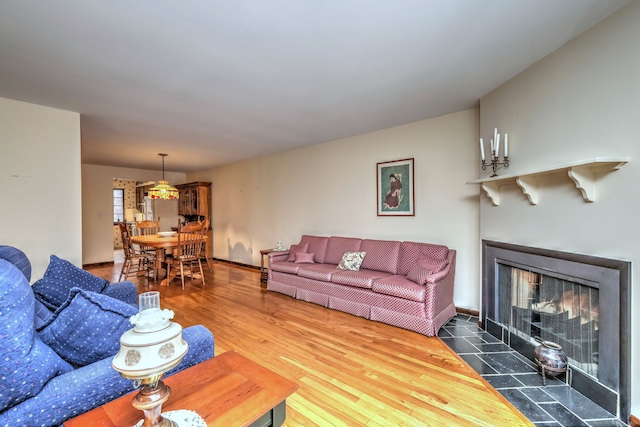 living room with a tile fireplace and hardwood / wood-style flooring