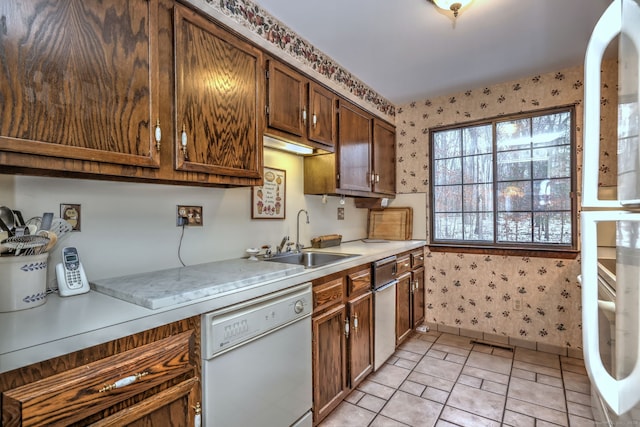 kitchen with dishwasher, light tile patterned flooring, and sink