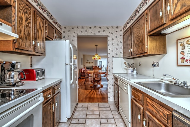 kitchen featuring sink, hanging light fixtures, stainless steel dishwasher, white dishwasher, and light tile patterned floors