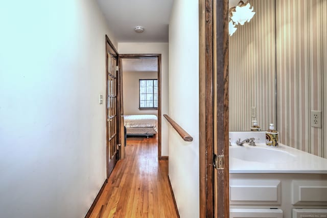 hallway with sink and hardwood / wood-style flooring