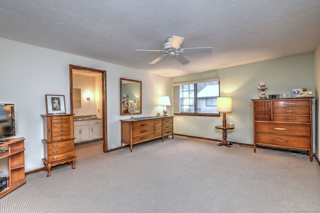 living area featuring ceiling fan, light colored carpet, and a textured ceiling