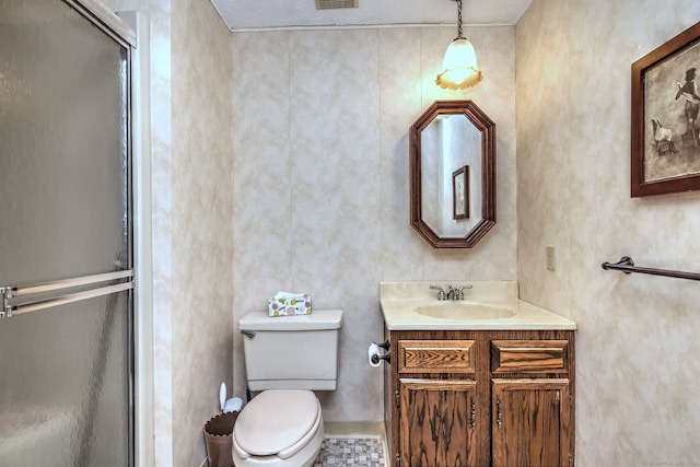 bathroom featuring tile patterned floors, vanity, toilet, and walk in shower